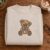 Diseño de bordado de osito de peluche con parches, bordado en una sudadera de cuello redondo