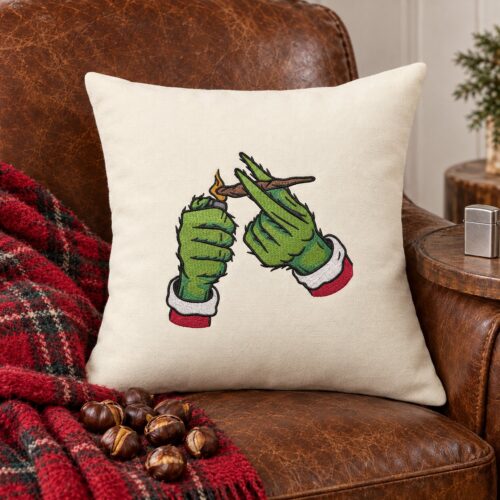 Diseño de bordado de las manos del Grinch fumando en Navidad, bordado en un cojín decorativo.