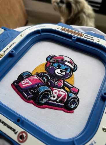 Cute bear racing a car embroidery design