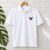 Diseño de bordado de mariposa rosa y morada bordado como logotipo en el lado izquierdo del pecho de una camisa polo.