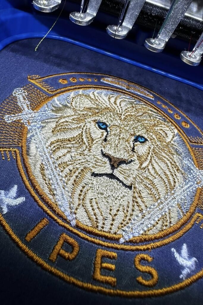 IPES lion crest embroidery stitched on a cap