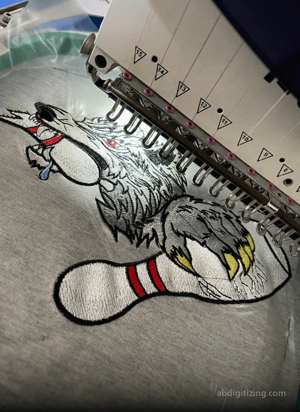 machine emboridery of a wolf holding a bowl with the claws